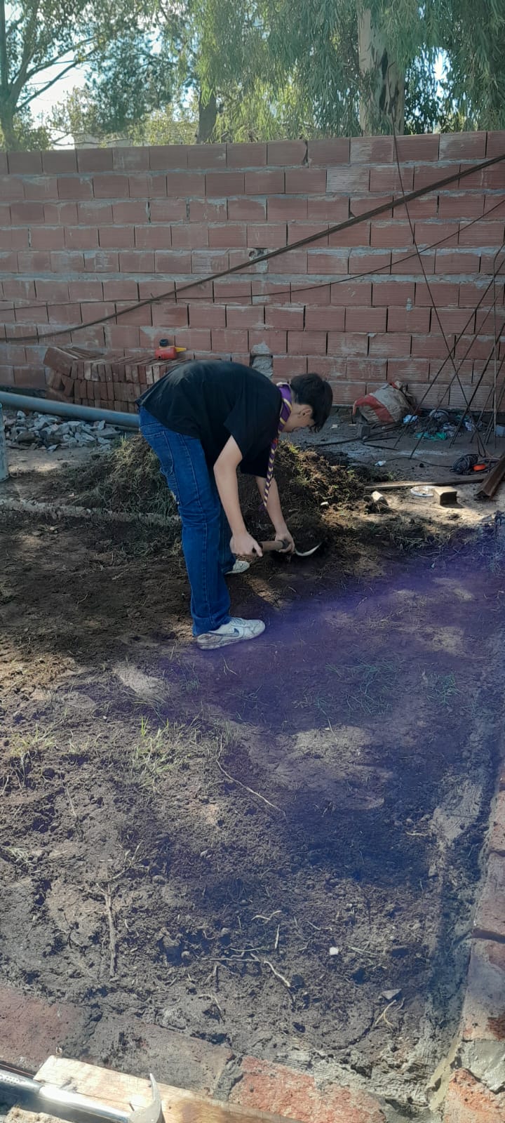 Voluntario removiendo tierra en el terreno del SUM